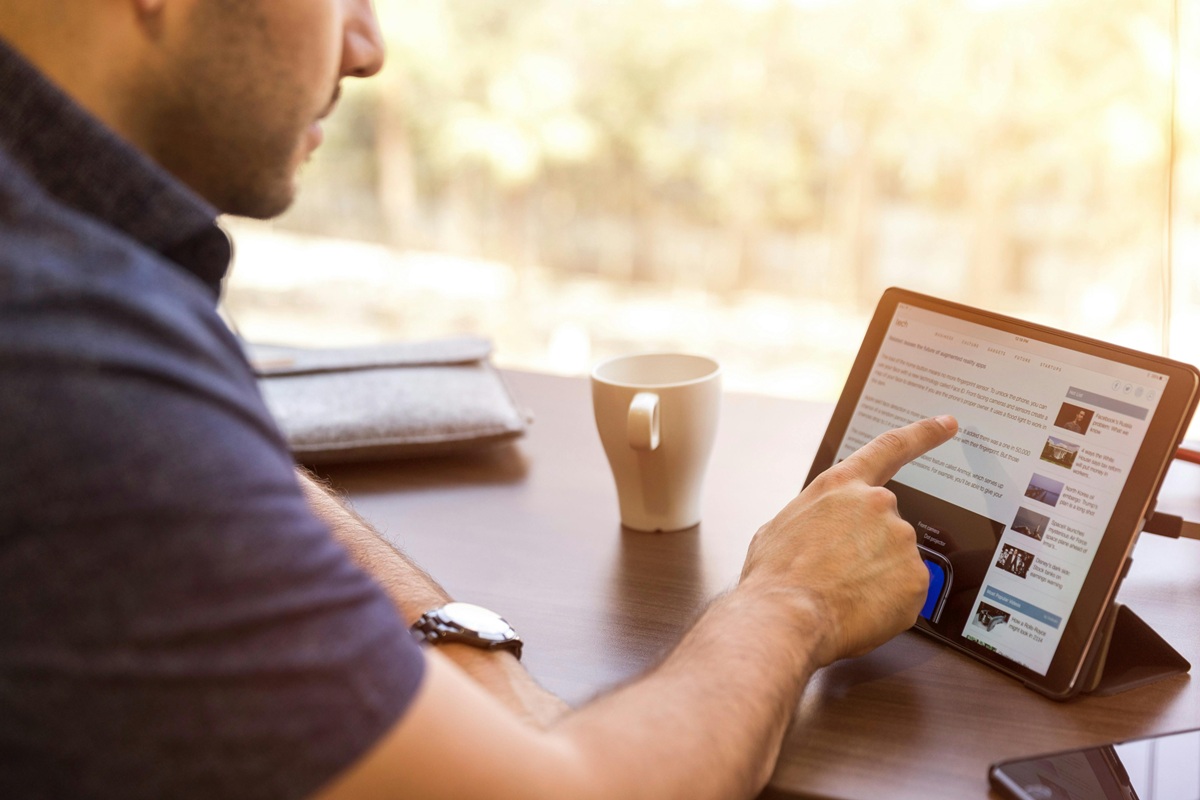 man looking and pointing at computer on table